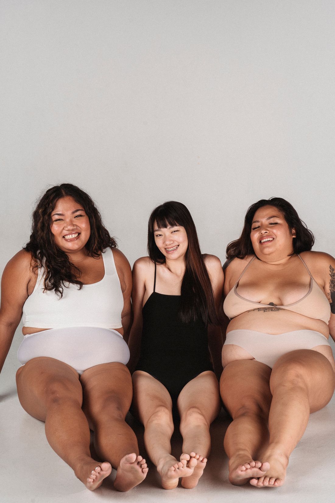 Three women sharing a joyful studio portrait